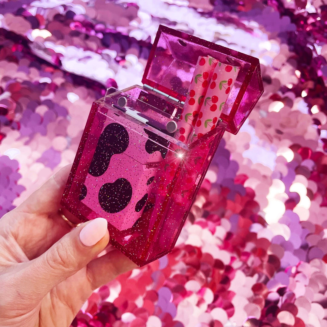 Pink glitter cigarette box holding cigarettes and lighter