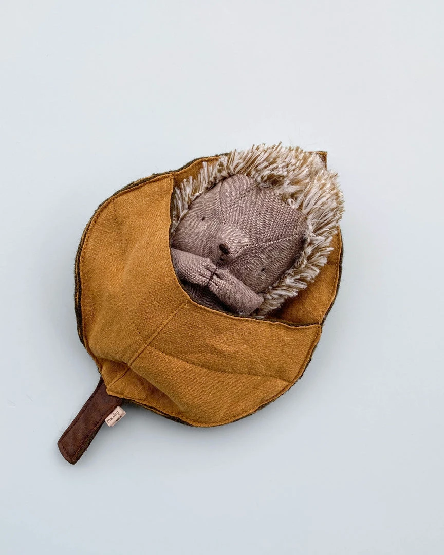 Maileg Hedgehog plush toy nestled in green leaf