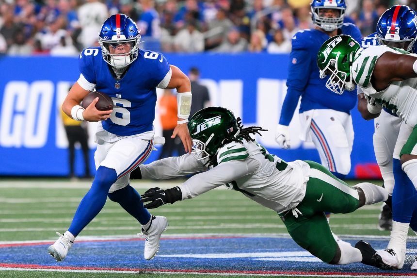 New York Giants quarterback Jaxson Dart runs with the ball as New York Jets defensive end Kingsley Jonathan defends during the preseason.