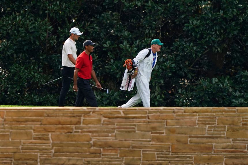 Scheffler and Woods walk down the 16th fairway with Woods' caddie Joe LeCava during the final round of the Masters golf tournament on November 15, 2020, in Augusta, Georgia.