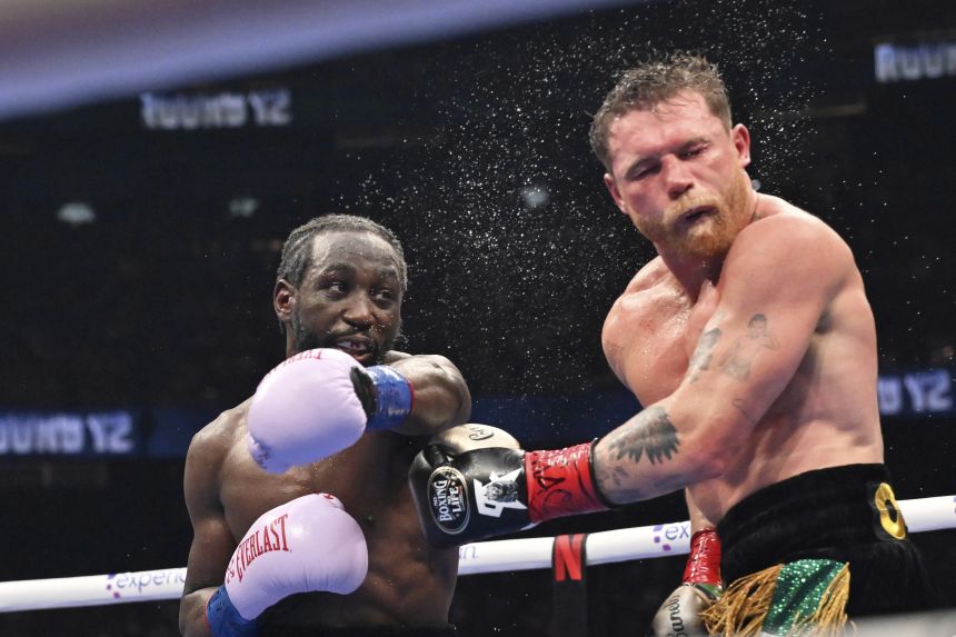 Terence Crawford, left, punches Canelo Alvarez during a super middleweight championship boxing match in Las Vegas on Saturday.